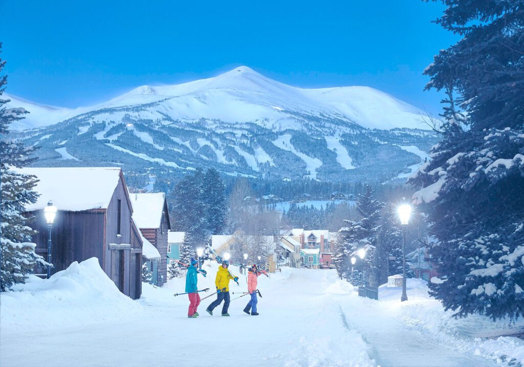 Skiers strolling through Breckenridge on a snowy day
