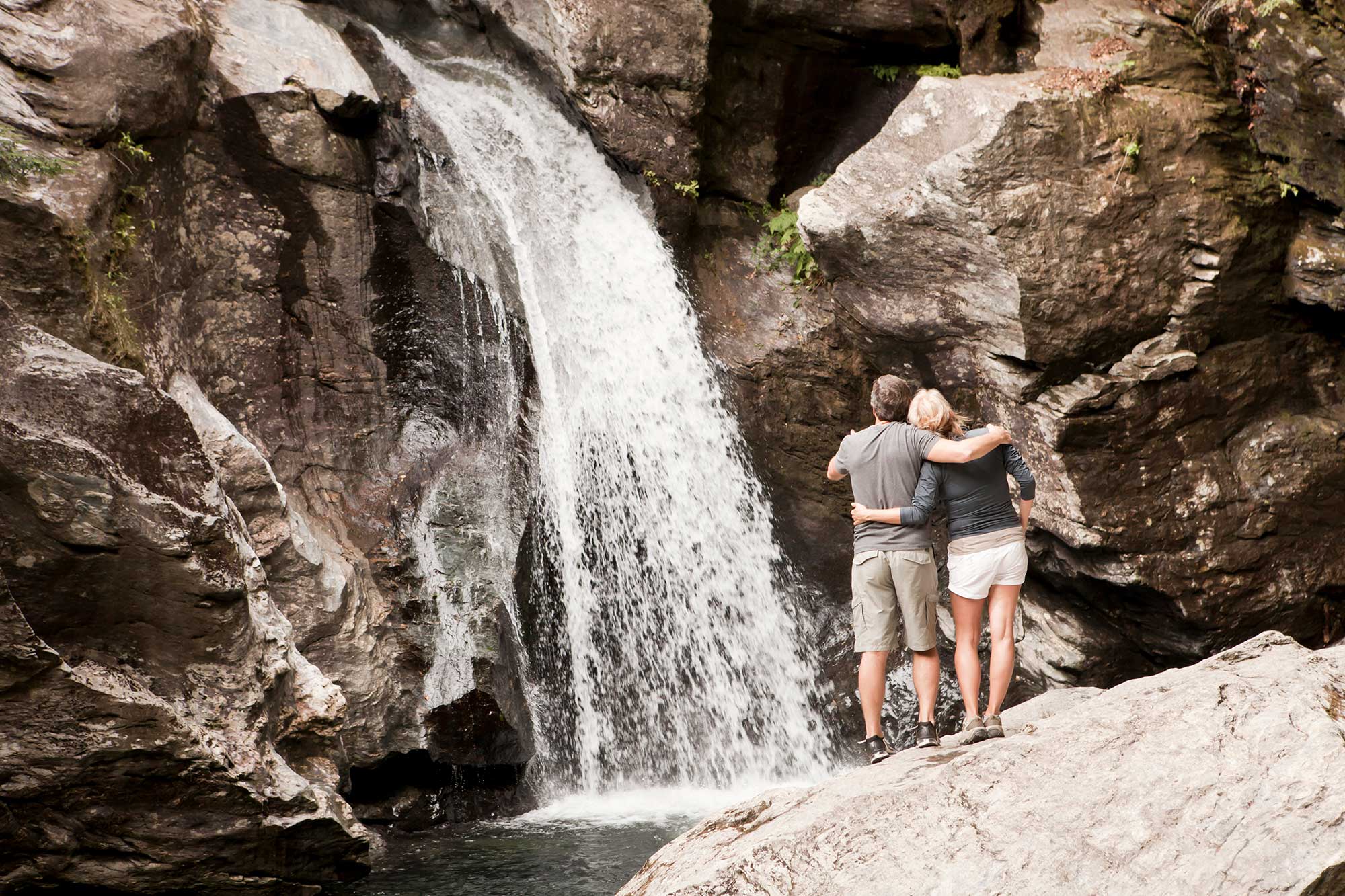 A couple admires a cascading waterfall near Stowe, Vermont