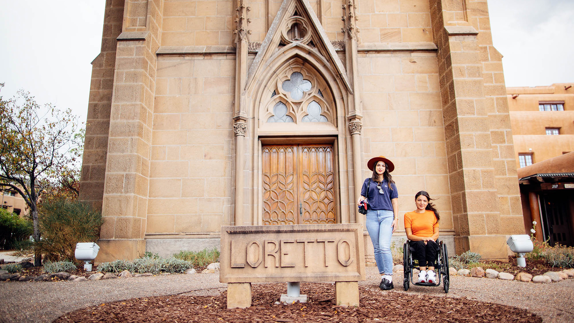 Two women outside the Loretto Chapel in Santa Fe, New Mexico