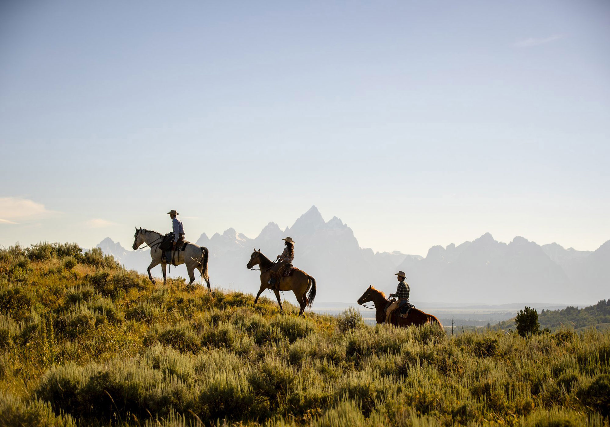 Visitors on a horseback ride while staying at a dude ranch in Wyoming