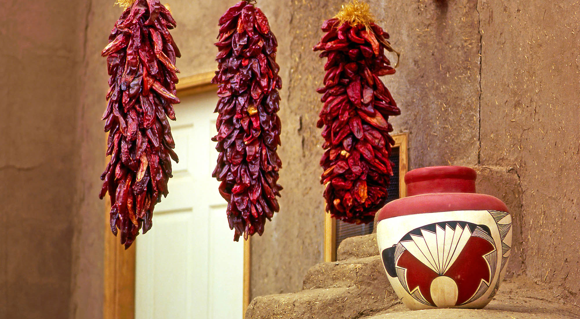 Pottery and peppers outside an adobe building in Taos, New Mexico