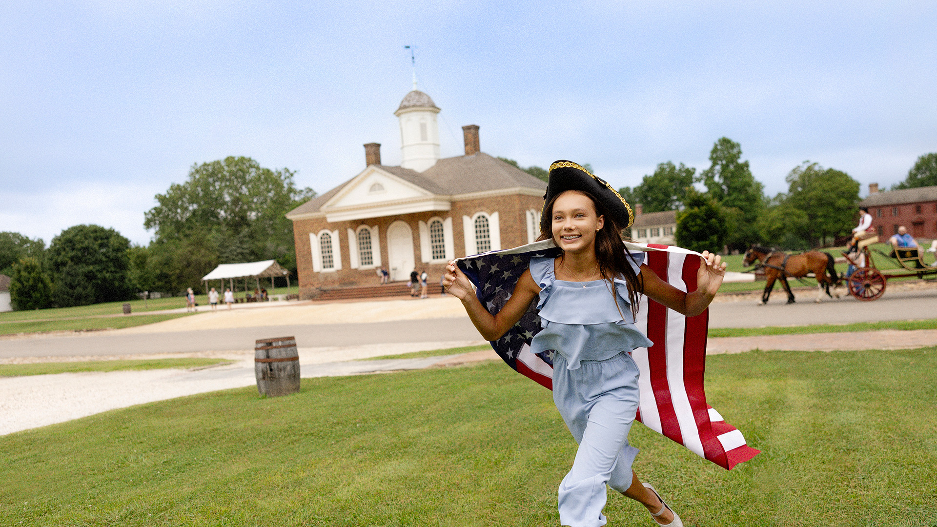 A young girl with an American flag at Colonial Williamsburg in Williamsburg, Virginia