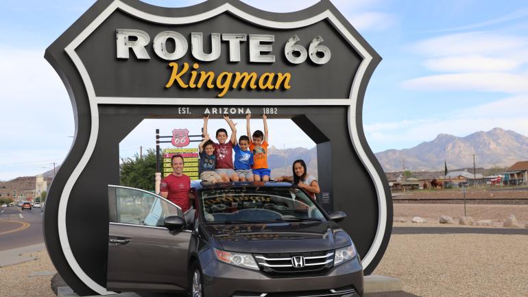Taking a group photo at the Route 66 Drive-Thru Shield in Kingman; Credit: Kingman Office of Tourism
