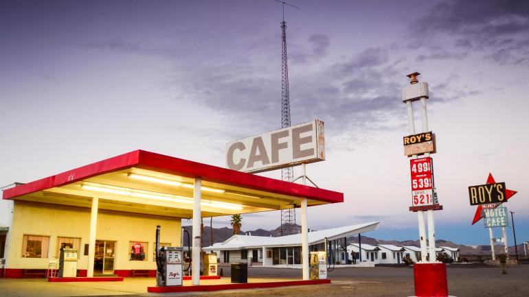 Rоу’ѕ Motel & Café illuminated at dusk
