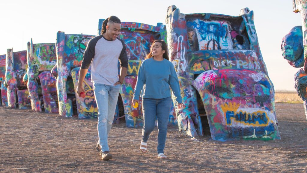 Walking along the half-buried, spraypainted cars of Cadillac Ranch in Amarillo, Texas; Credit: Visit Amarillo
