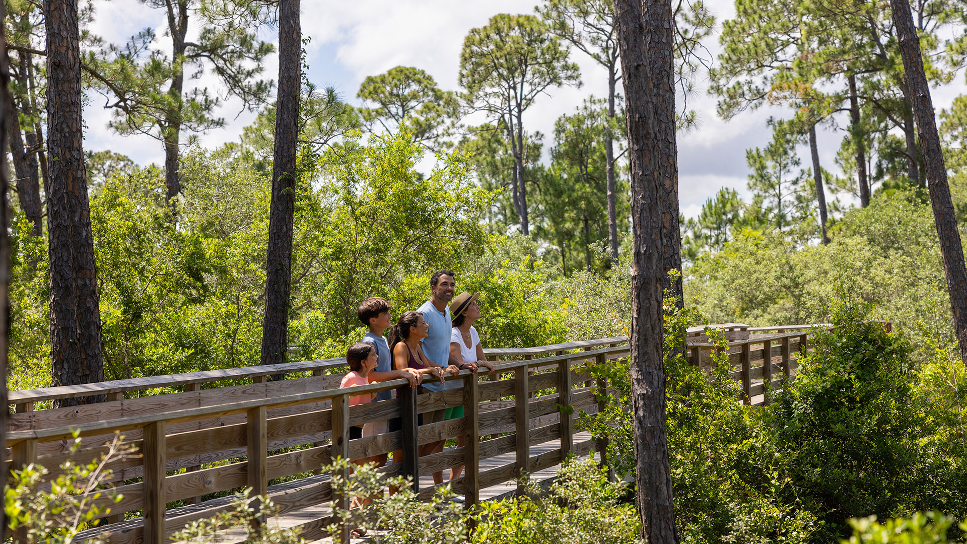 Family exploring a boardwalk trail in Gulf State Park, Alabama
