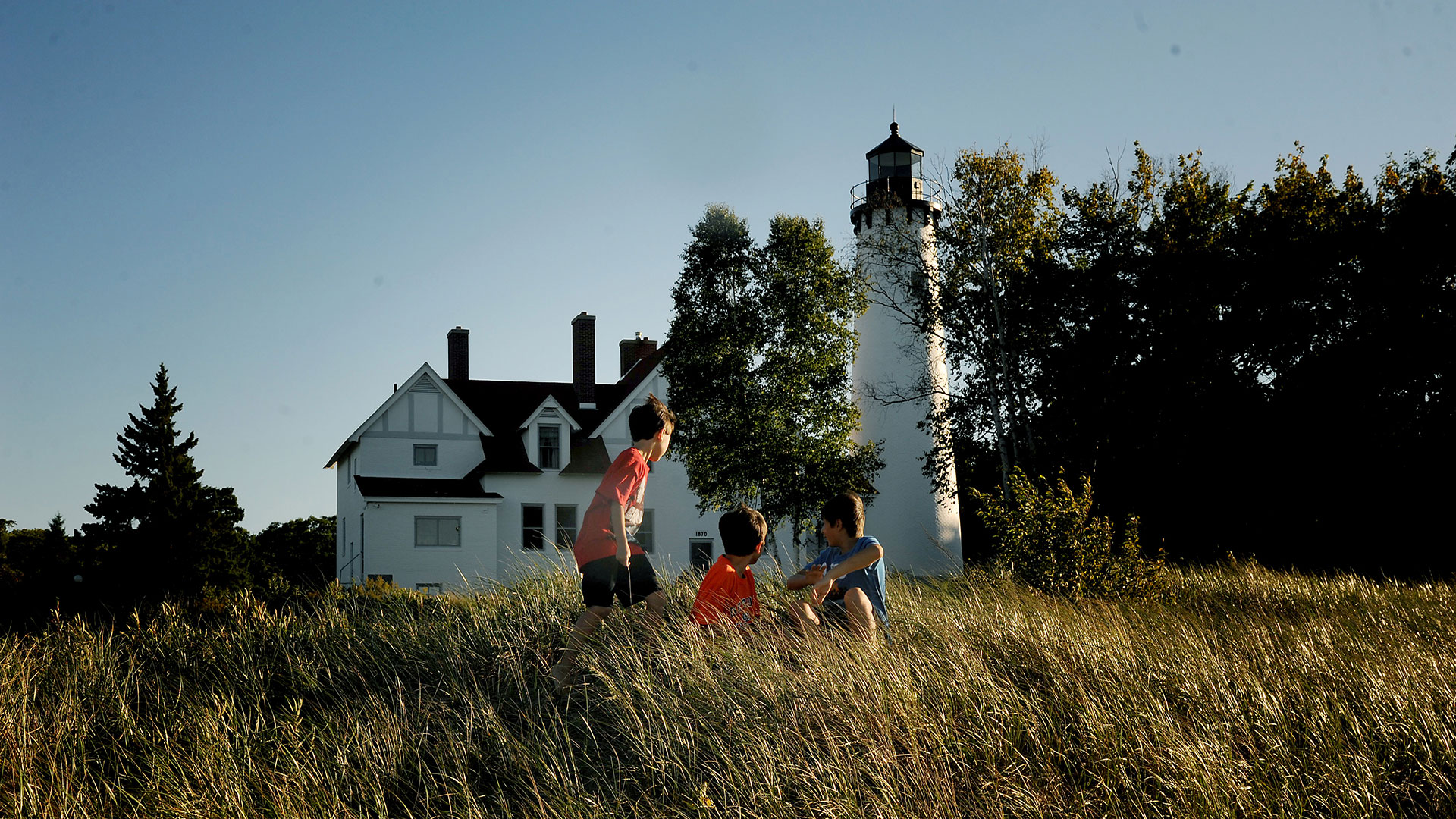 Kids in front of the Point Iroquois Lighthouse near Salt Ste. Marie, Michigan