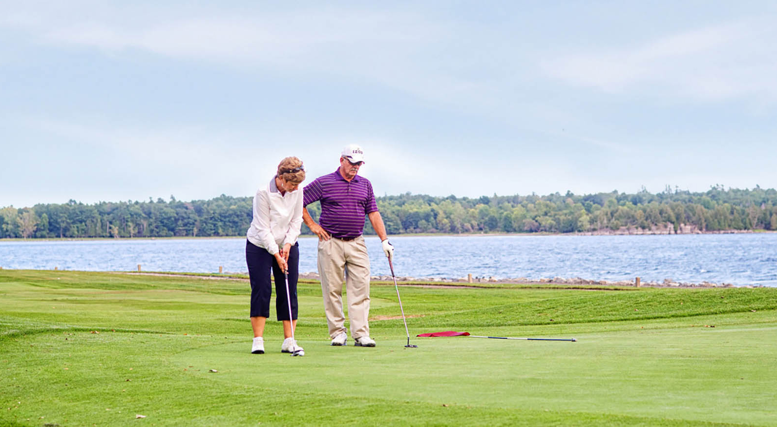 Un couple jouant au golf au Bluff Point Golf Resort à Plattsburgh, New York; Crédit : Bureau des visiteurs de la côte des Adirondacks