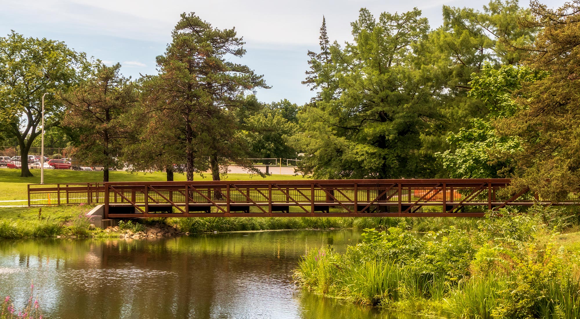 캔자스주 토피카 게이지 공원에 있는 그림 같은 호수 위의 다리