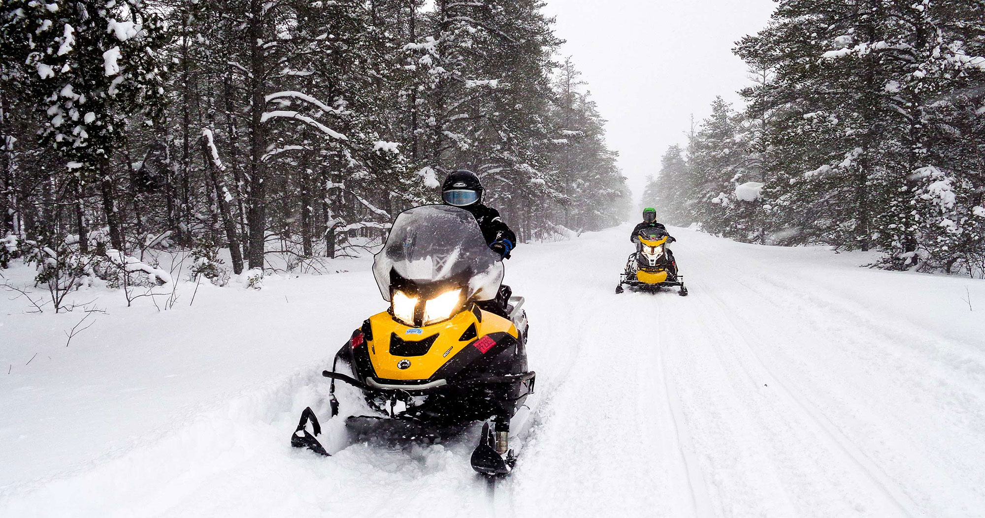 Snowmobilers on snow-covered trail near Sault Ste. Marie, Michigan