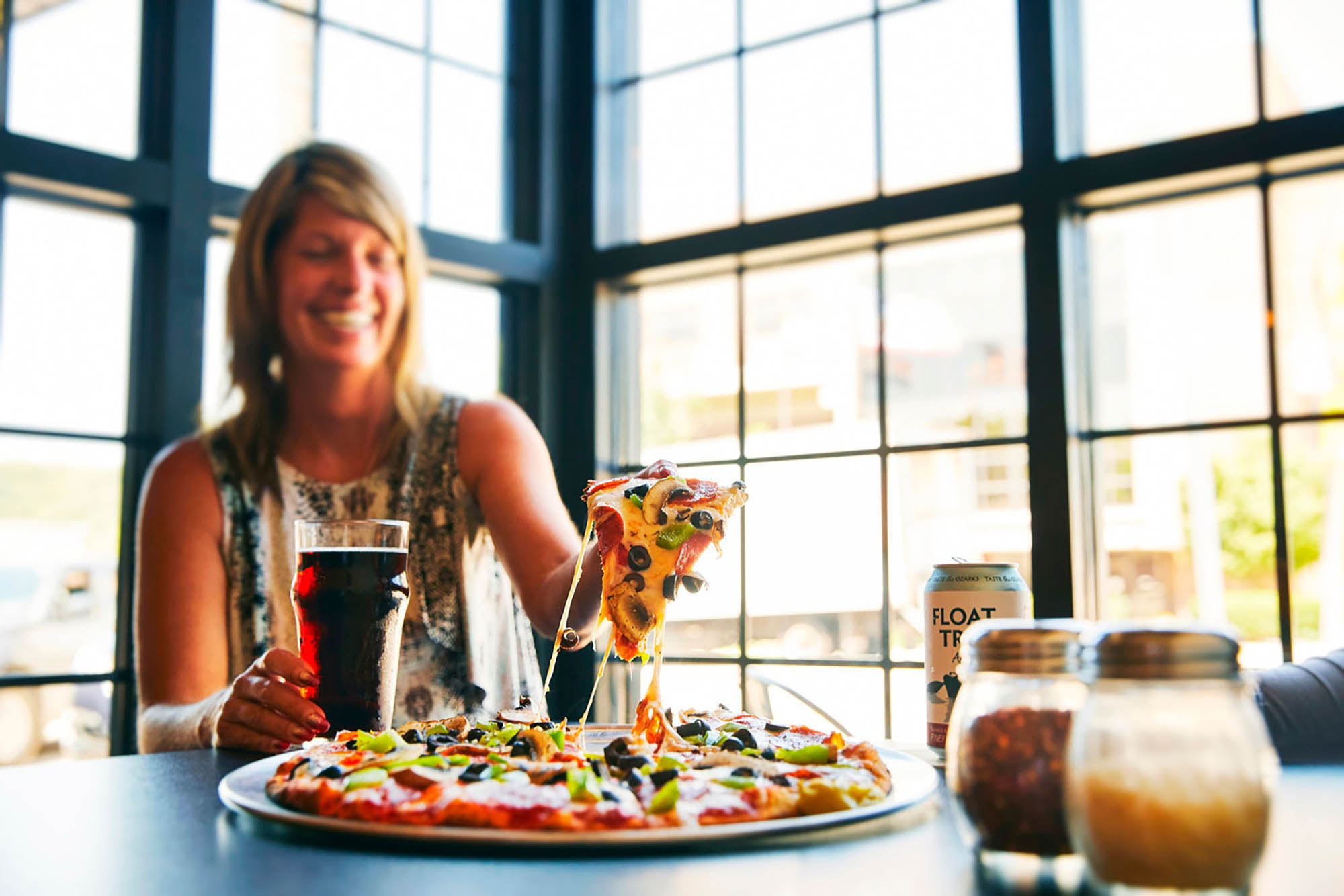 Una donna mentre mangia una pizza alla PaPPo’s Pizzeria &amp; Pub a St. Robert, nel Missouri; Foto: Ufficio del Turismo della Contea di Pulaski
