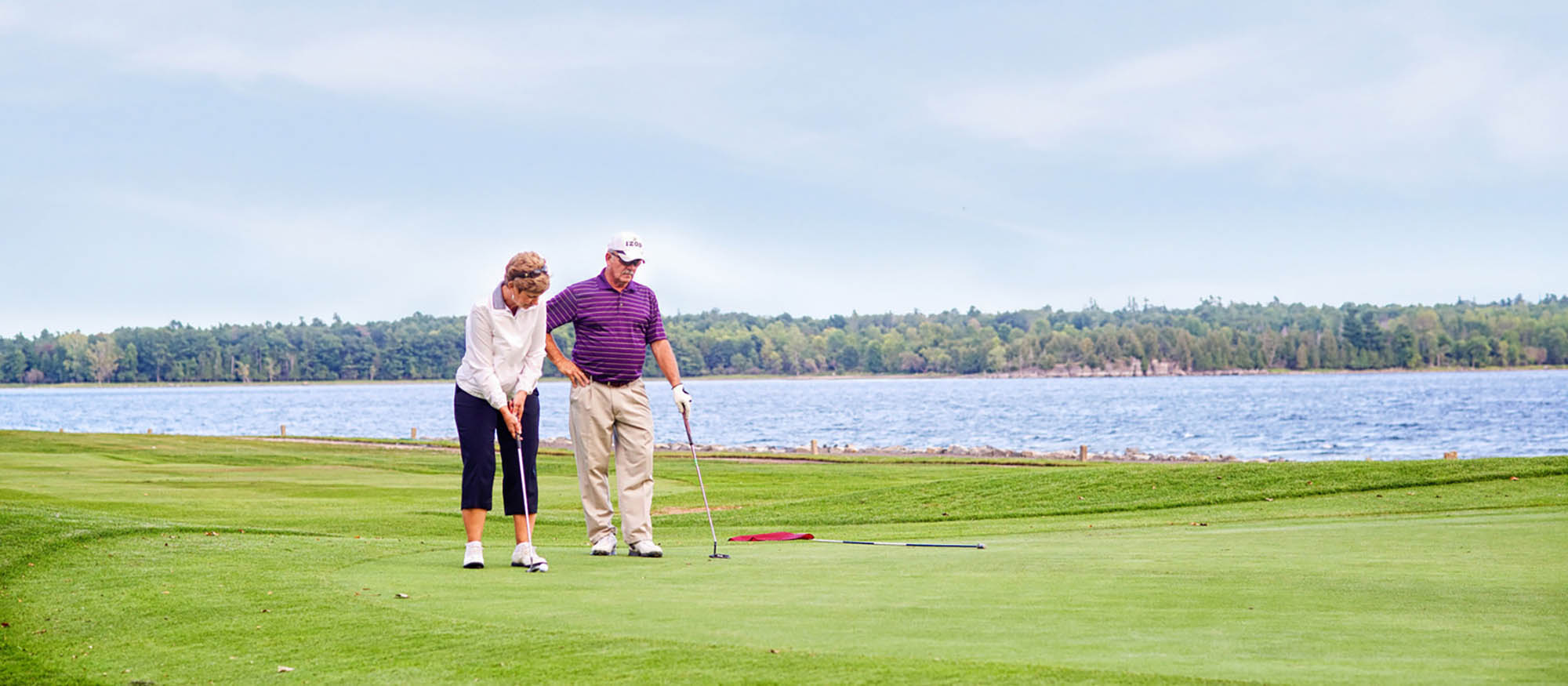 A couple playing golf at the Bluff Point Golf Resort in Plattsburgh, New York; Credit: Adirondack Coast Visitors Bureau