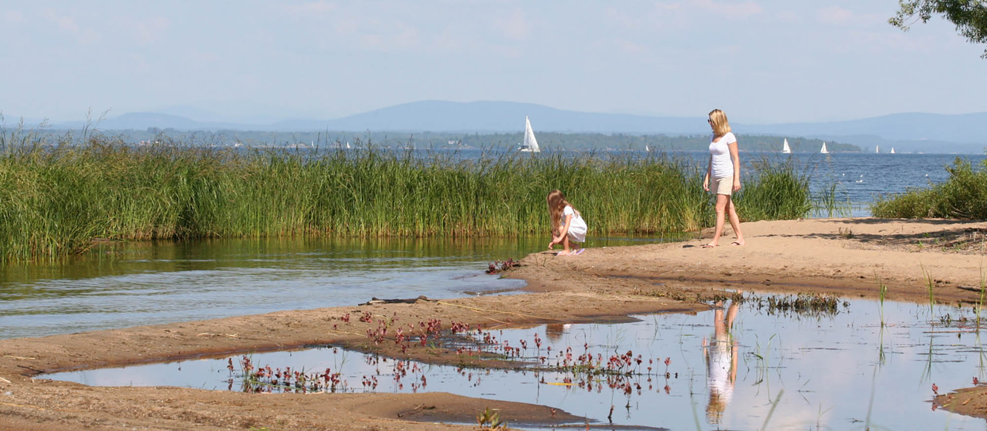 A mother and daughter exploring the shores of Lake Champlain in Plattsburgh, New York; Credit: Adirondack Coast Visitors Bureau