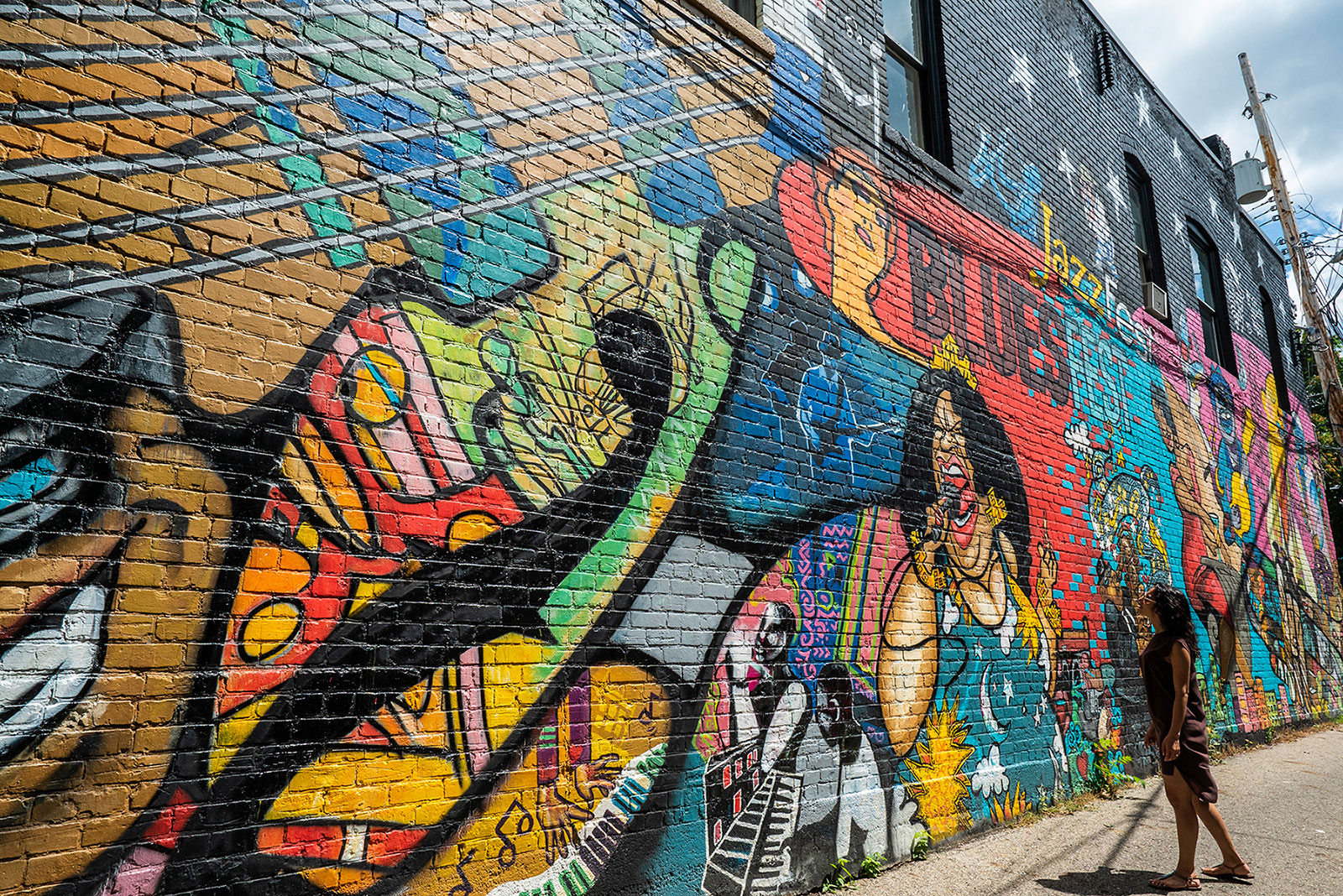 Des visiteurs admirent une fresque murale dans le quartier d'Old Town, à Lansing, Michigan