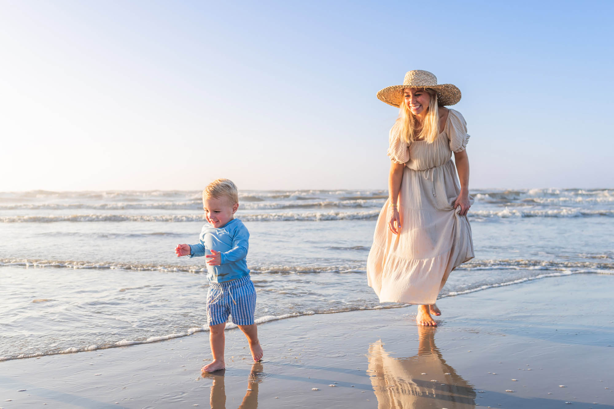 Uma mãe e seu filho caminhando pela praia em Port Aransas, Texas