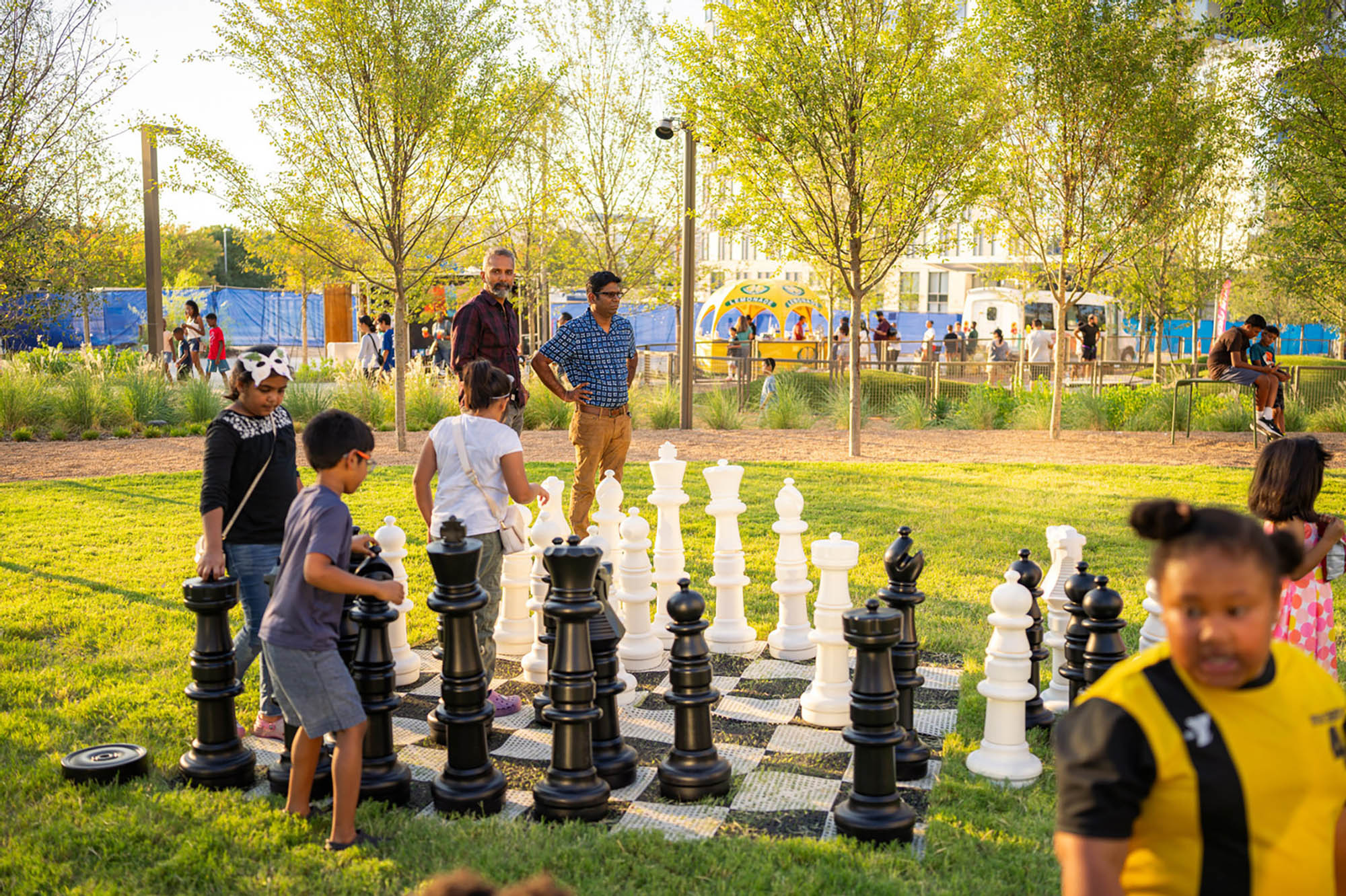 Crianças brincando com um jogo de xadrez gigante no Kaleidoscope Park, em Frisco, Texas; Crédito: Phillip Slaughter 