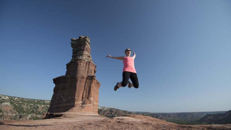 Lady celebrates near a rock formation