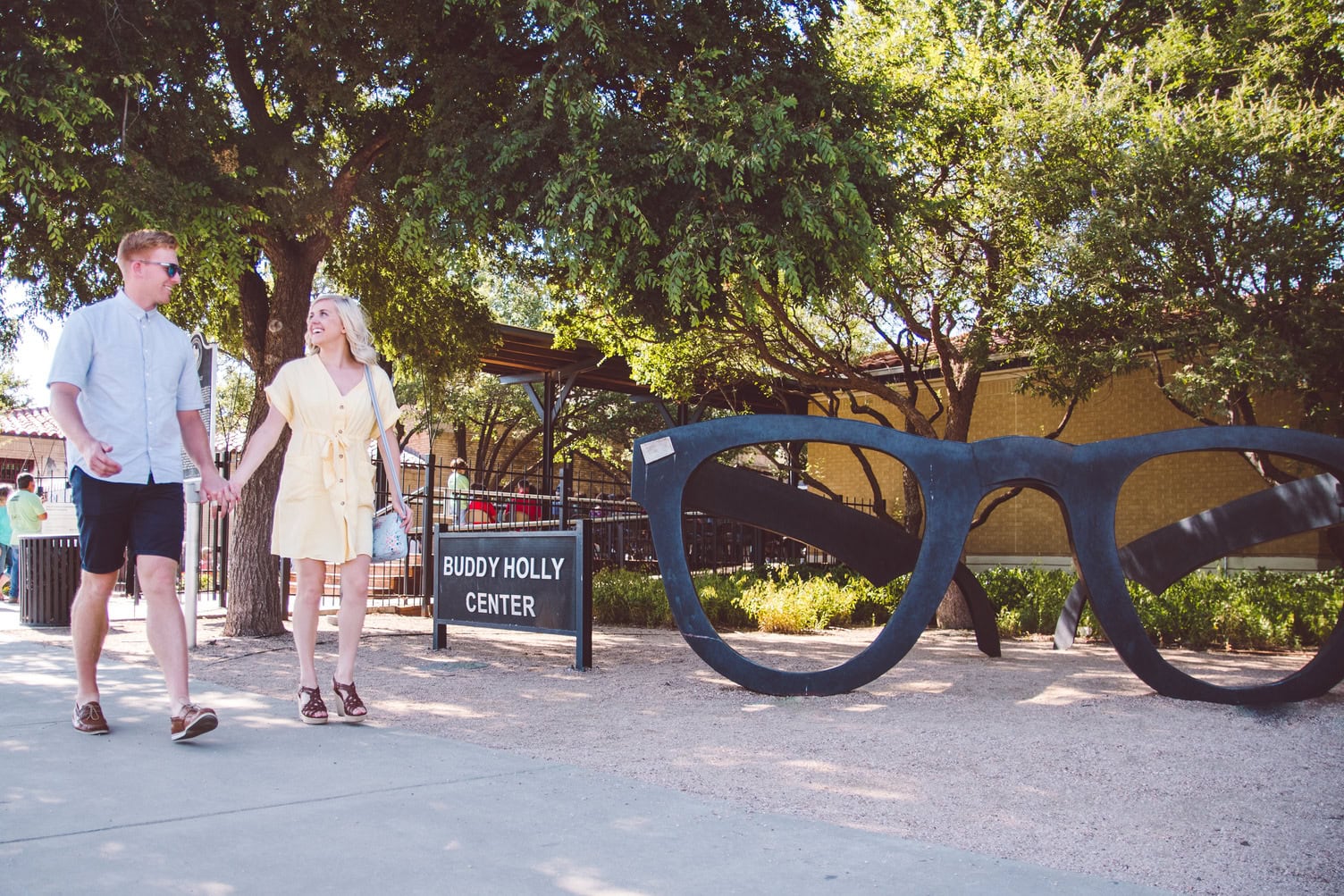 Persone che passano davanti alla statua degli occhiali di Buddy Holly al Buddy Holly Center di Lubbock, in Texas