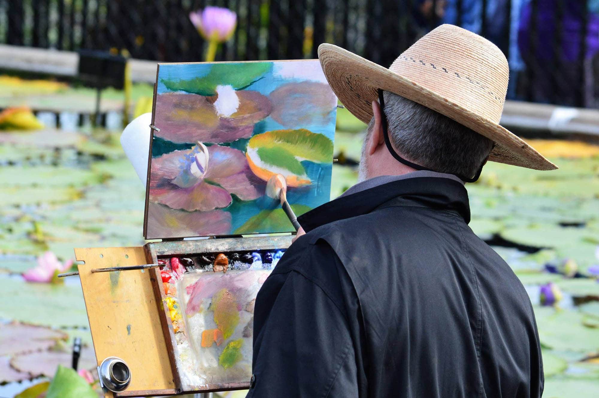 An artist painting water lilies in San Angelo, Texas during the EnPleinAirTEXAS competition.