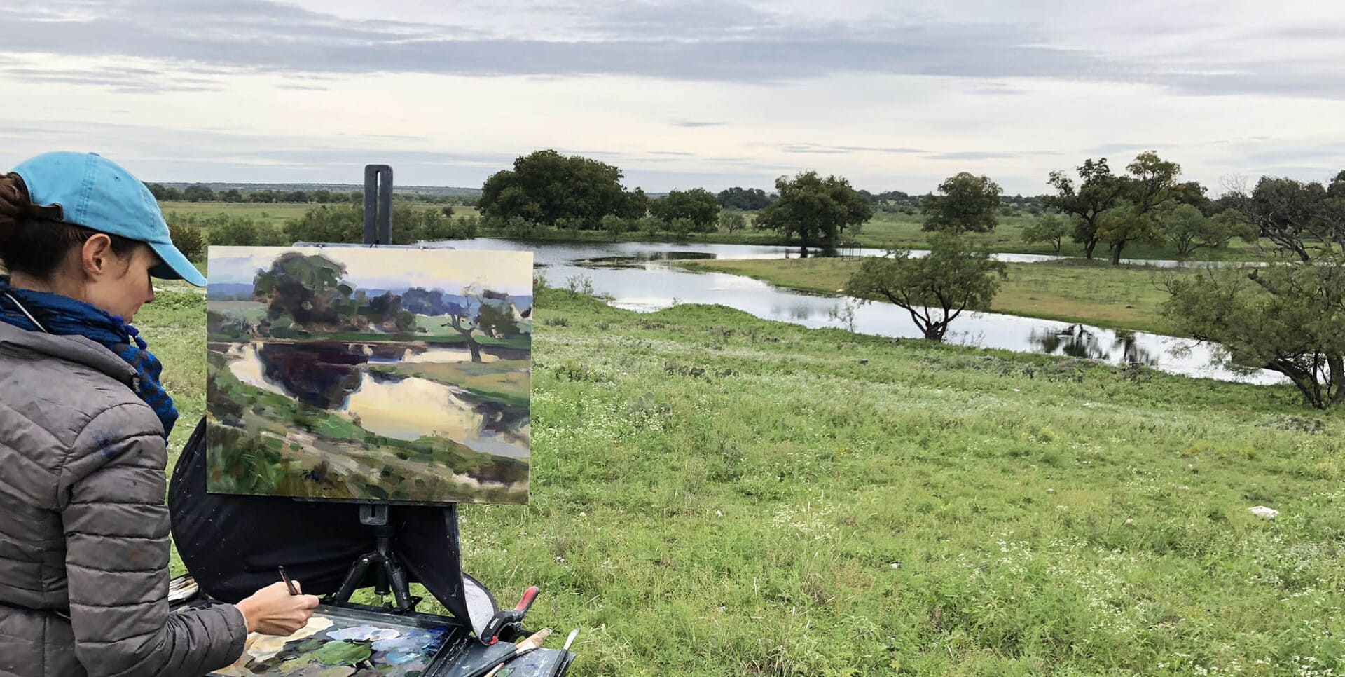 Un artista trabajando en un cuadro de paisaje durante el EnPleinAirTEXAS en San Angelo, Texas